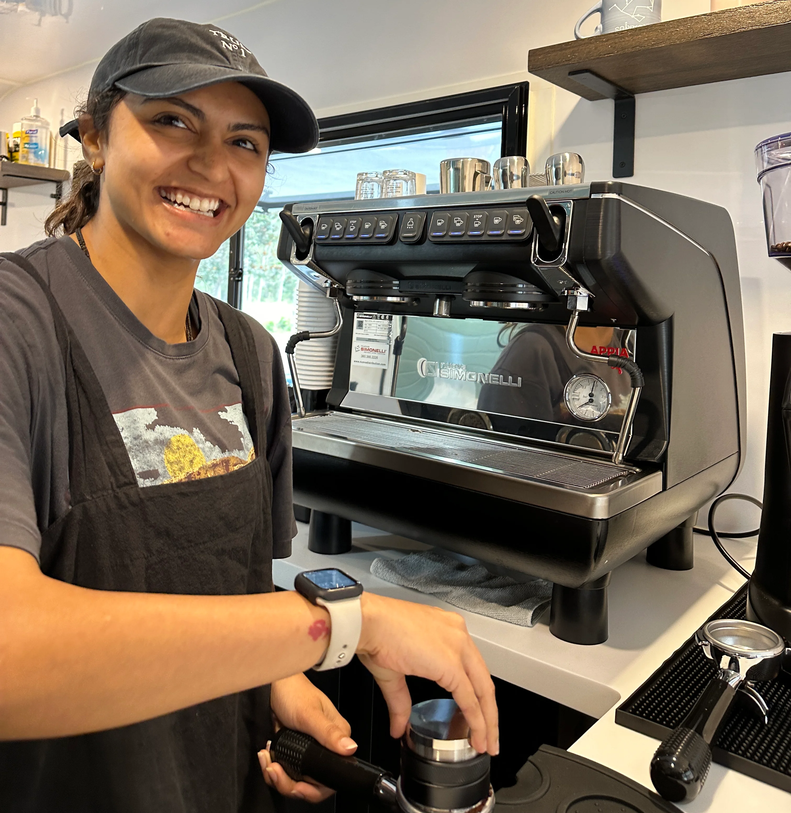 Barista smiling while preparing espresso at a coffee shop