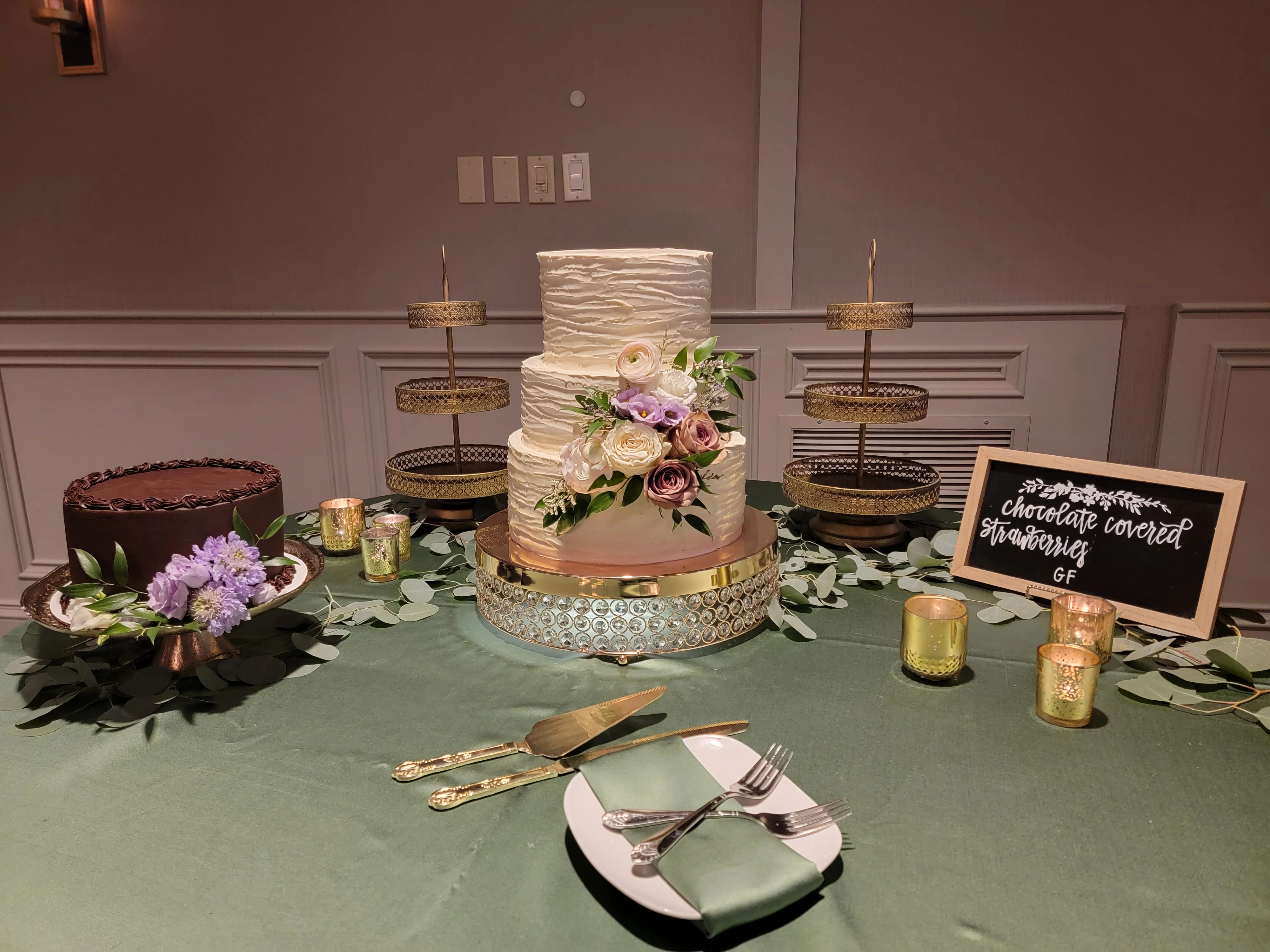 Elegant wedding dessert table with floral tiered cake and chocolate cake