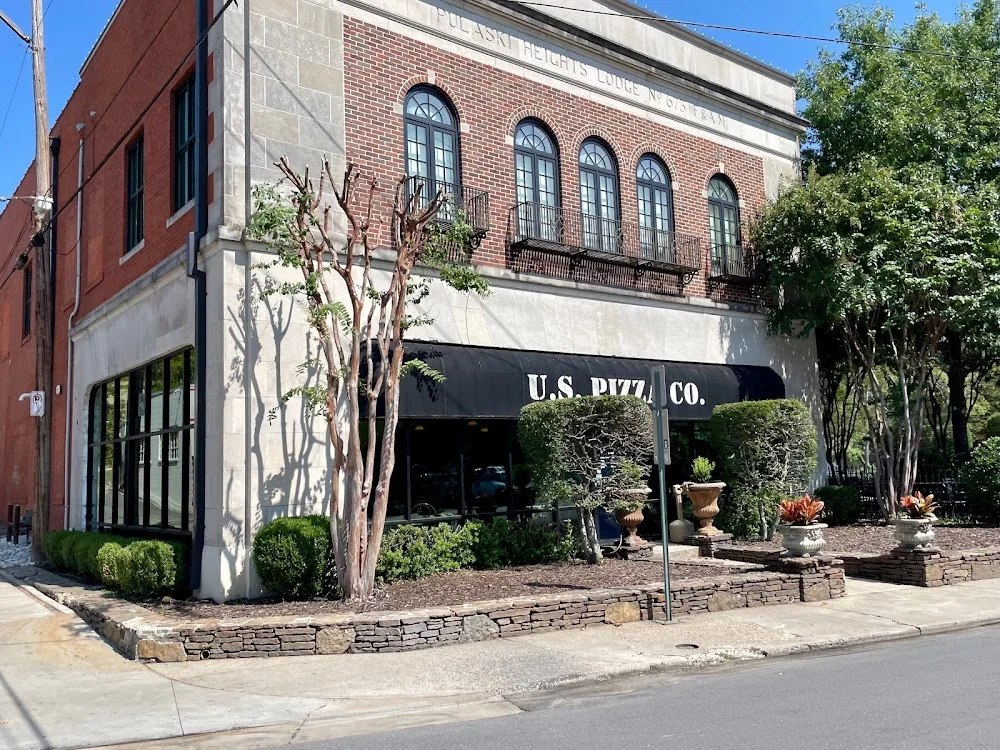 Charming restaurant exterior of U.S. Pizza Co. with greenery