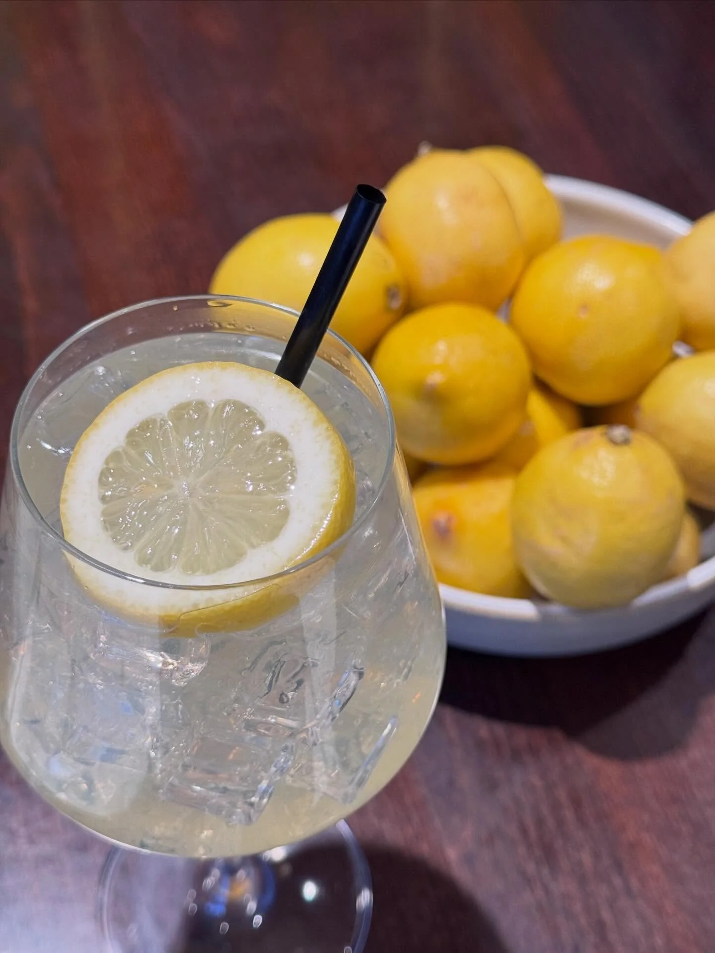 Refreshing lemonade cocktail with lemon slice and ice