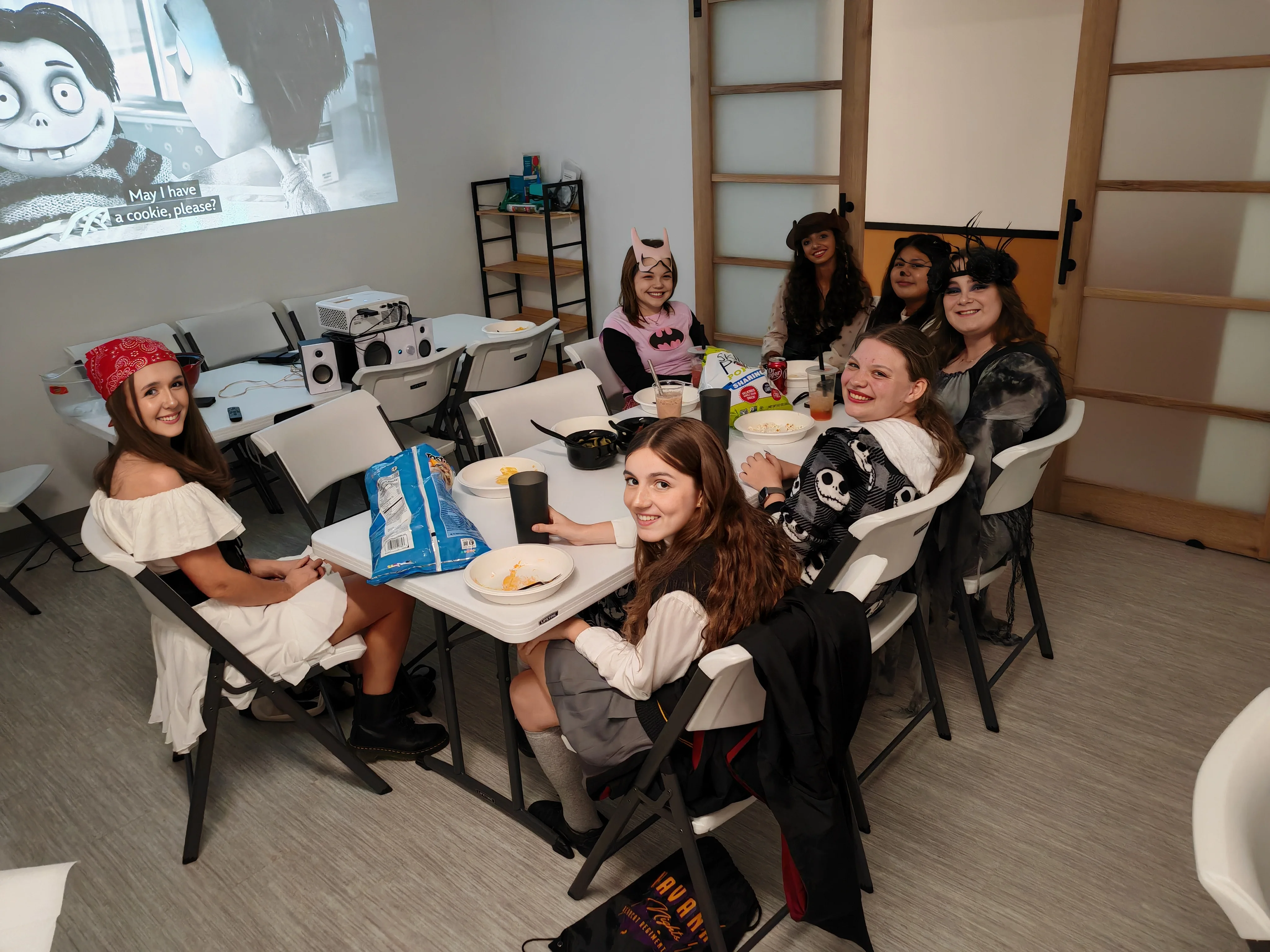 Group of friends in costumes enjoying snacks at a themed gathering