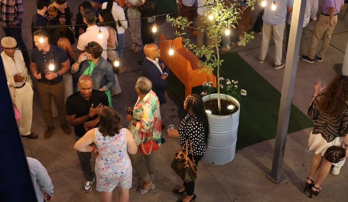A lively outdoor gathering with people socializing under string lights.