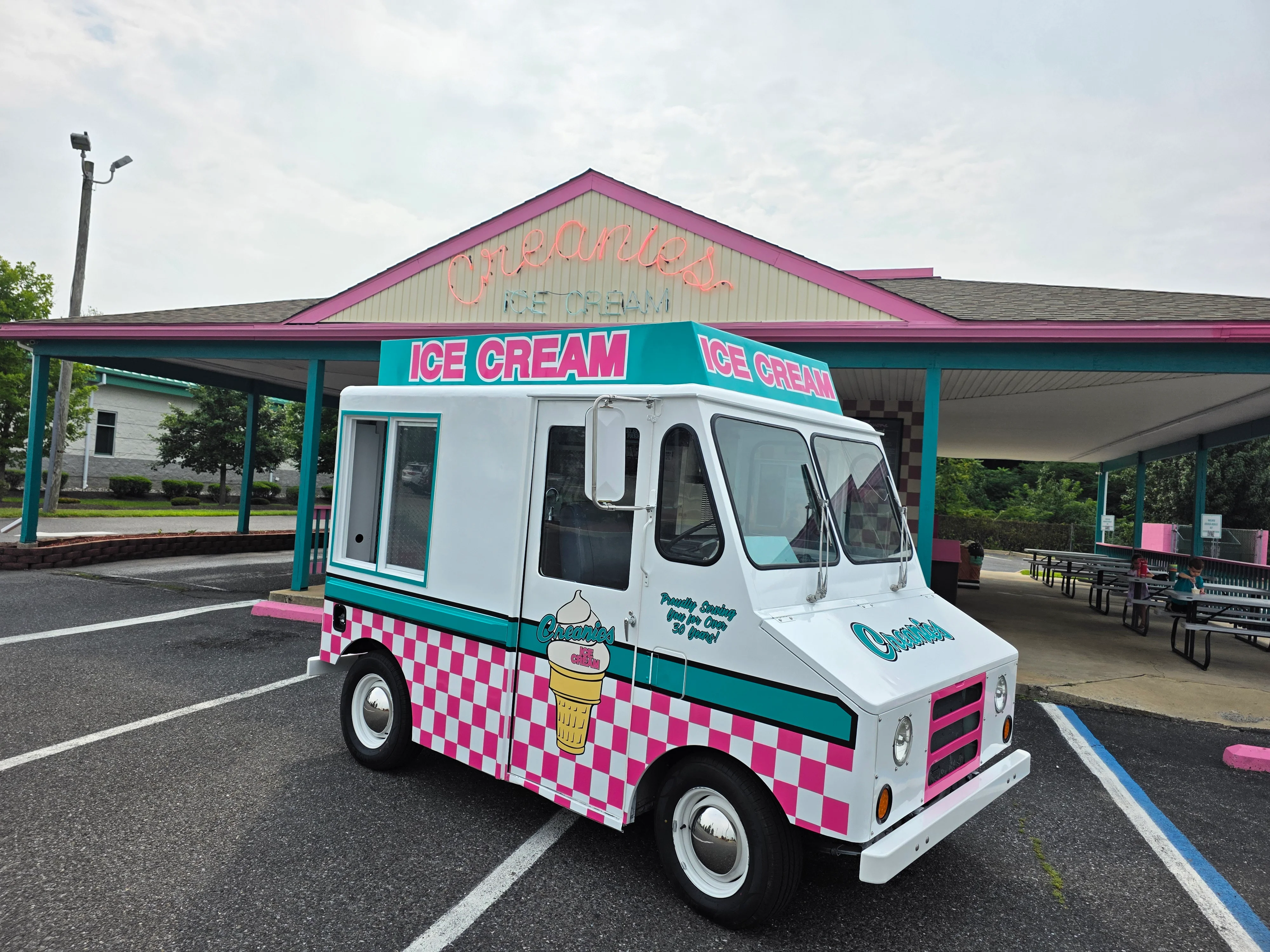 Colorful ice cream truck parked outside a retro ice cream stand