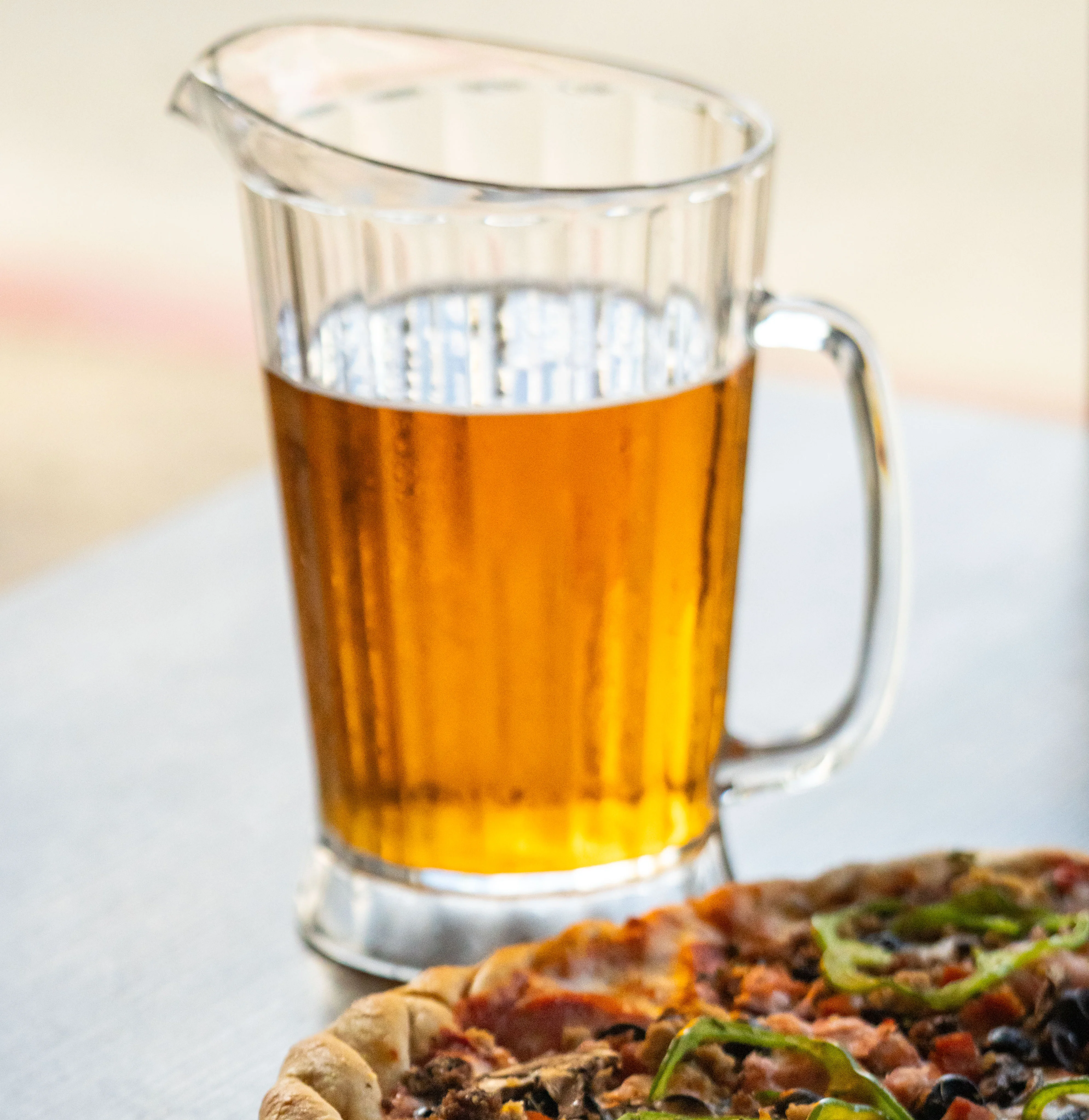 A delicious pizza with toppings and beer on a wooden table.