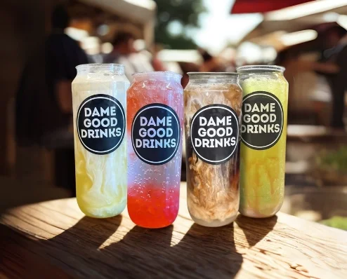 Colorful drinks in jars labeled 'Dame Good Drinks'