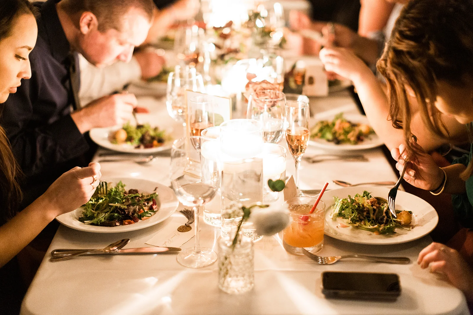 Elegant dining table with salads and drinks in a cozy restaurant setting