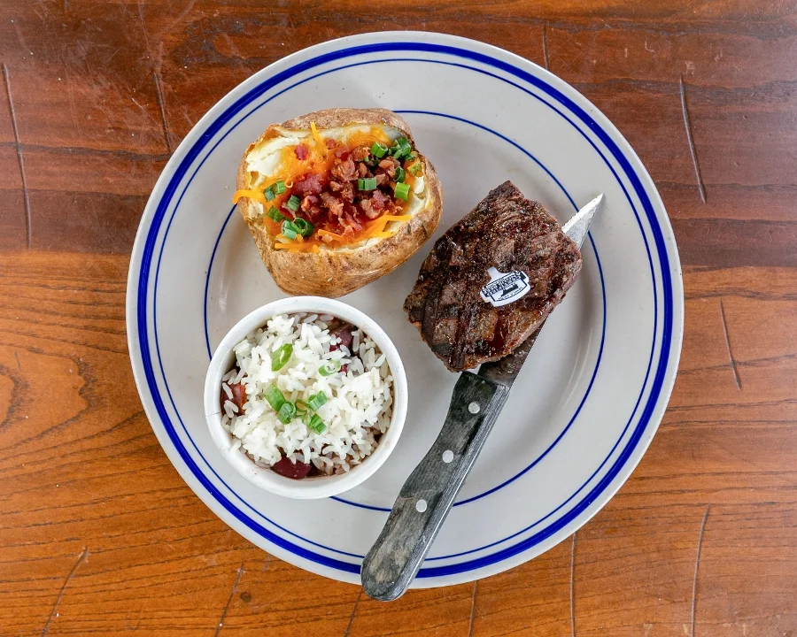 Grilled steak with baked potato and rice, classic American comfort food
