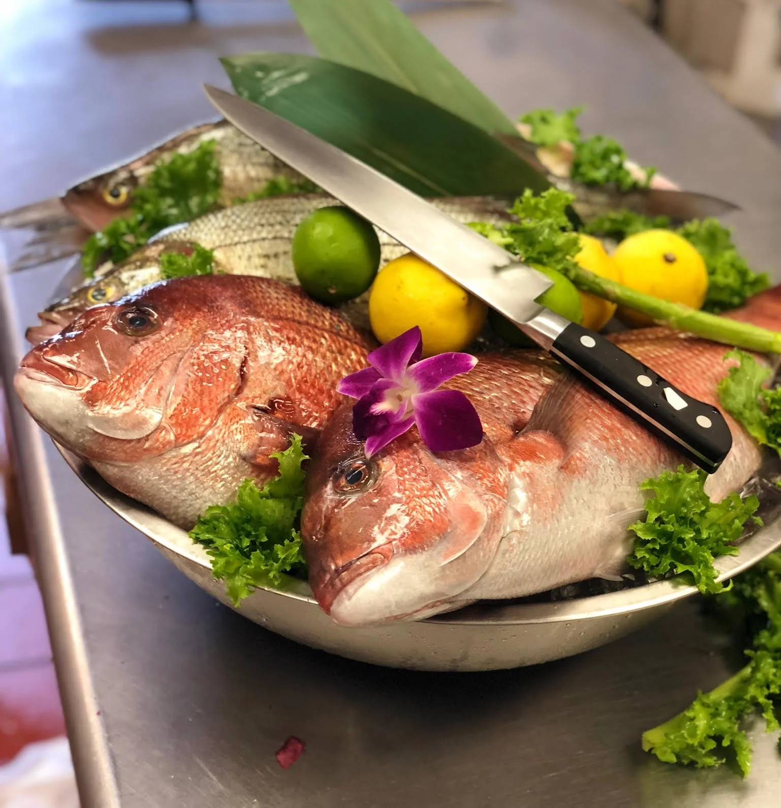 Fresh seafood platter featuring whole fish and garnishes