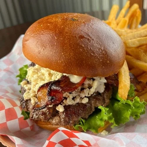 Delicious gourmet burger with fresh toppings on a wooden table