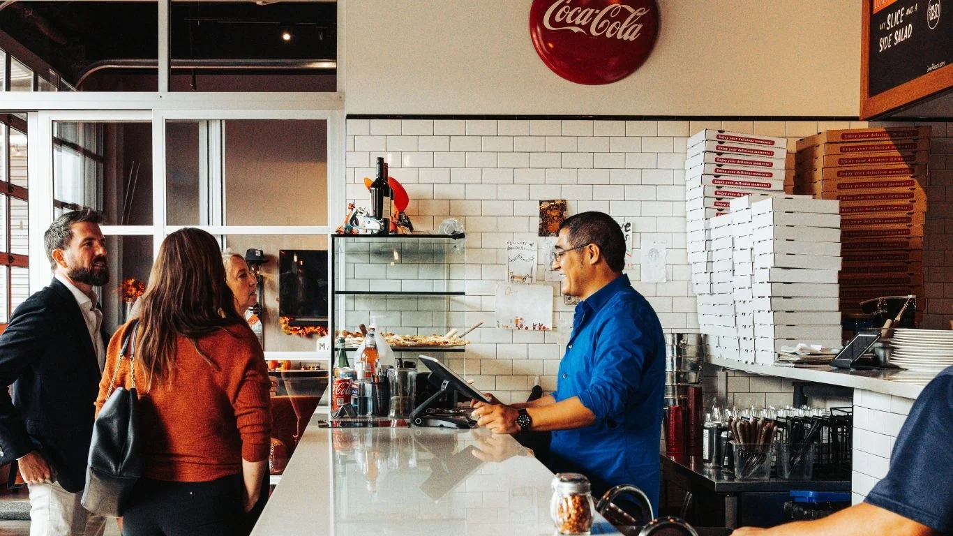 Friendly restaurant staff serving customers at the counter