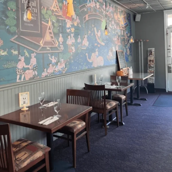 Cozy restaurant interior with colorful mural and wooden tables