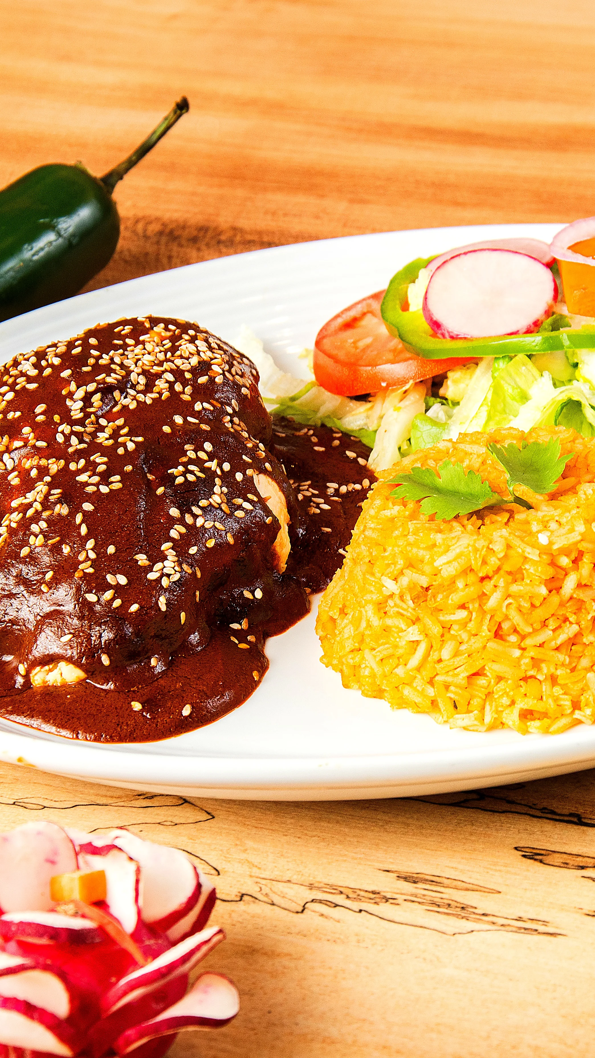 Authentic Mexican mole chicken with yellow rice and fresh salad