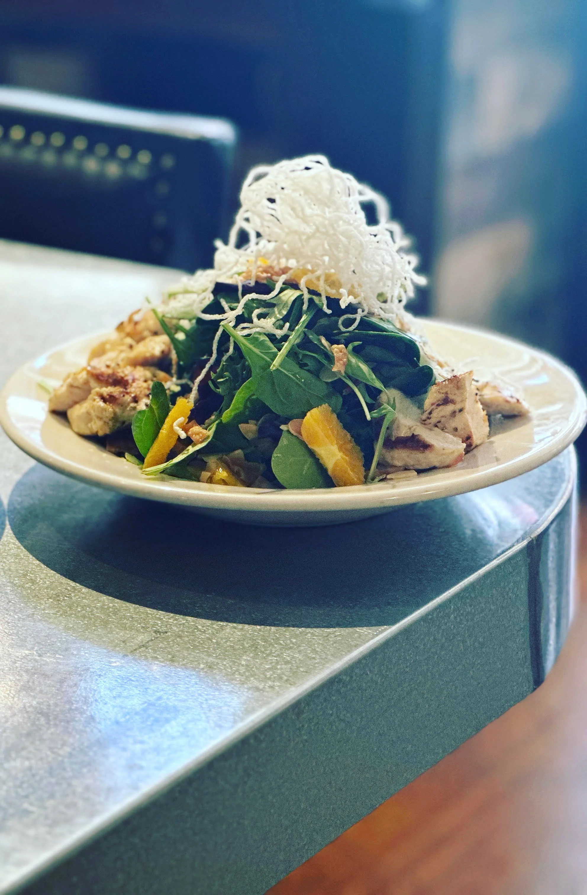 A vibrant Asian chicken salad with colorful vegetables and dressing.