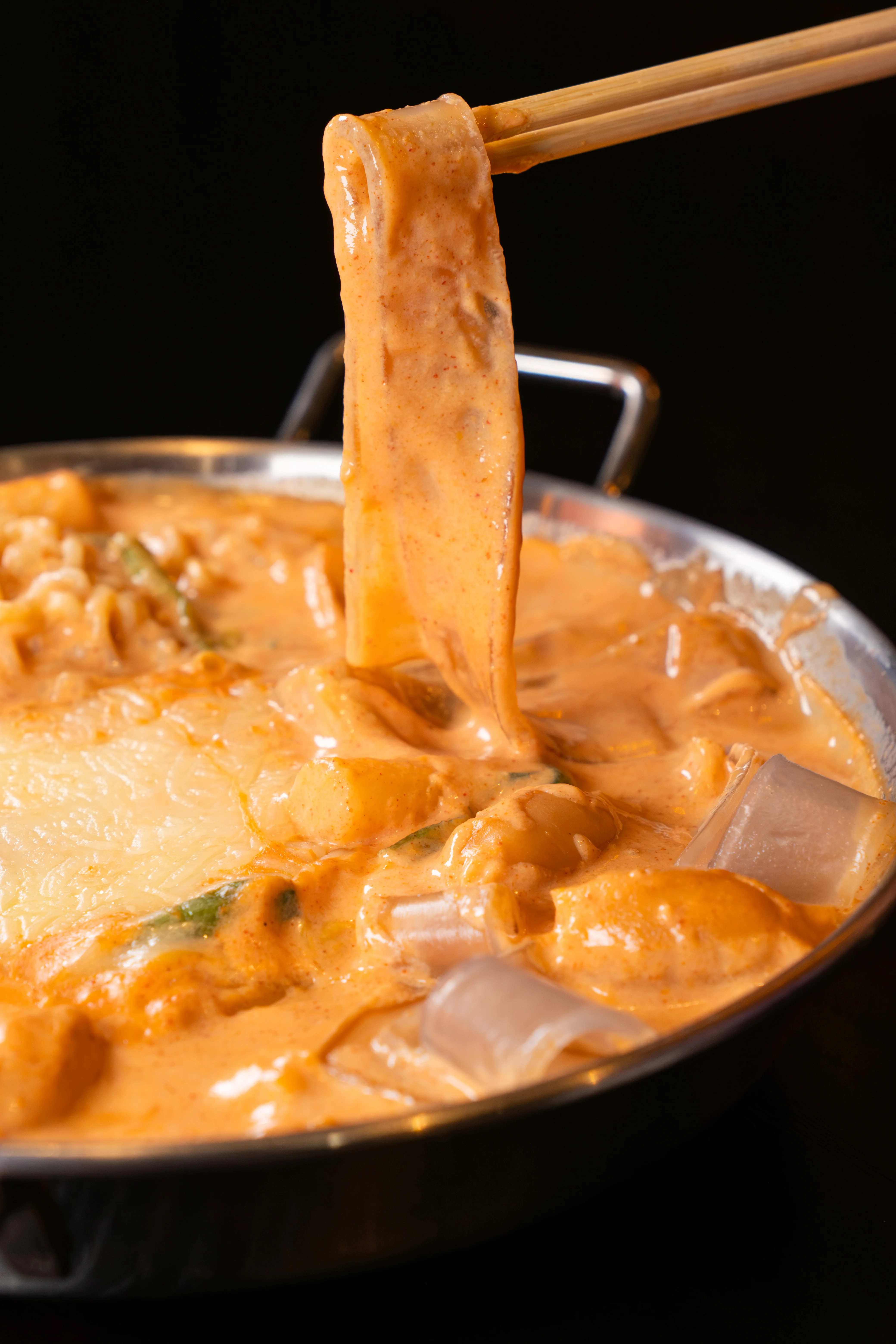 Creamy noodle dish with vegetables in a rich sauce, served in a pan.