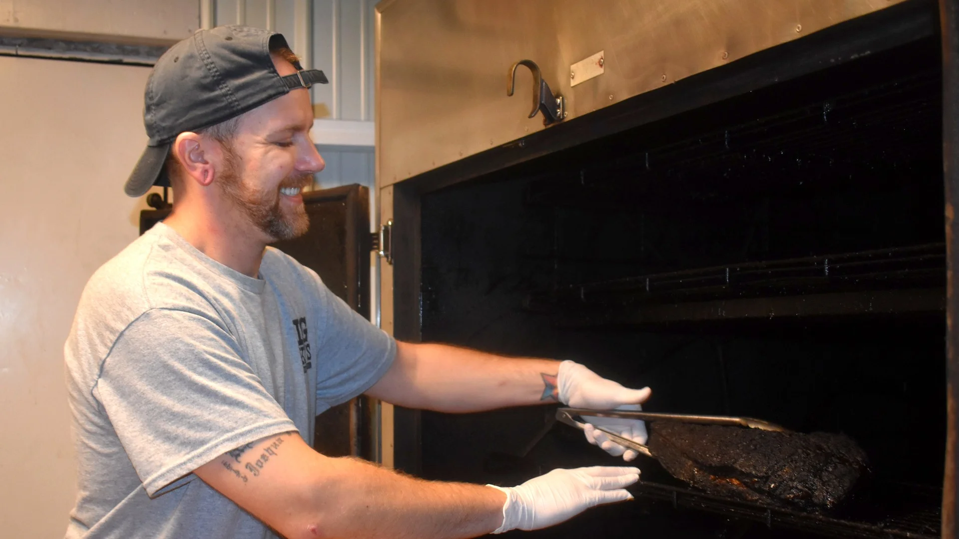 Co-owner Corey Lyons pulling a brisket from the smoker at Big Mike's Smokin' BBQ. Photo: Marilyn Forbes, The Daily Courier
