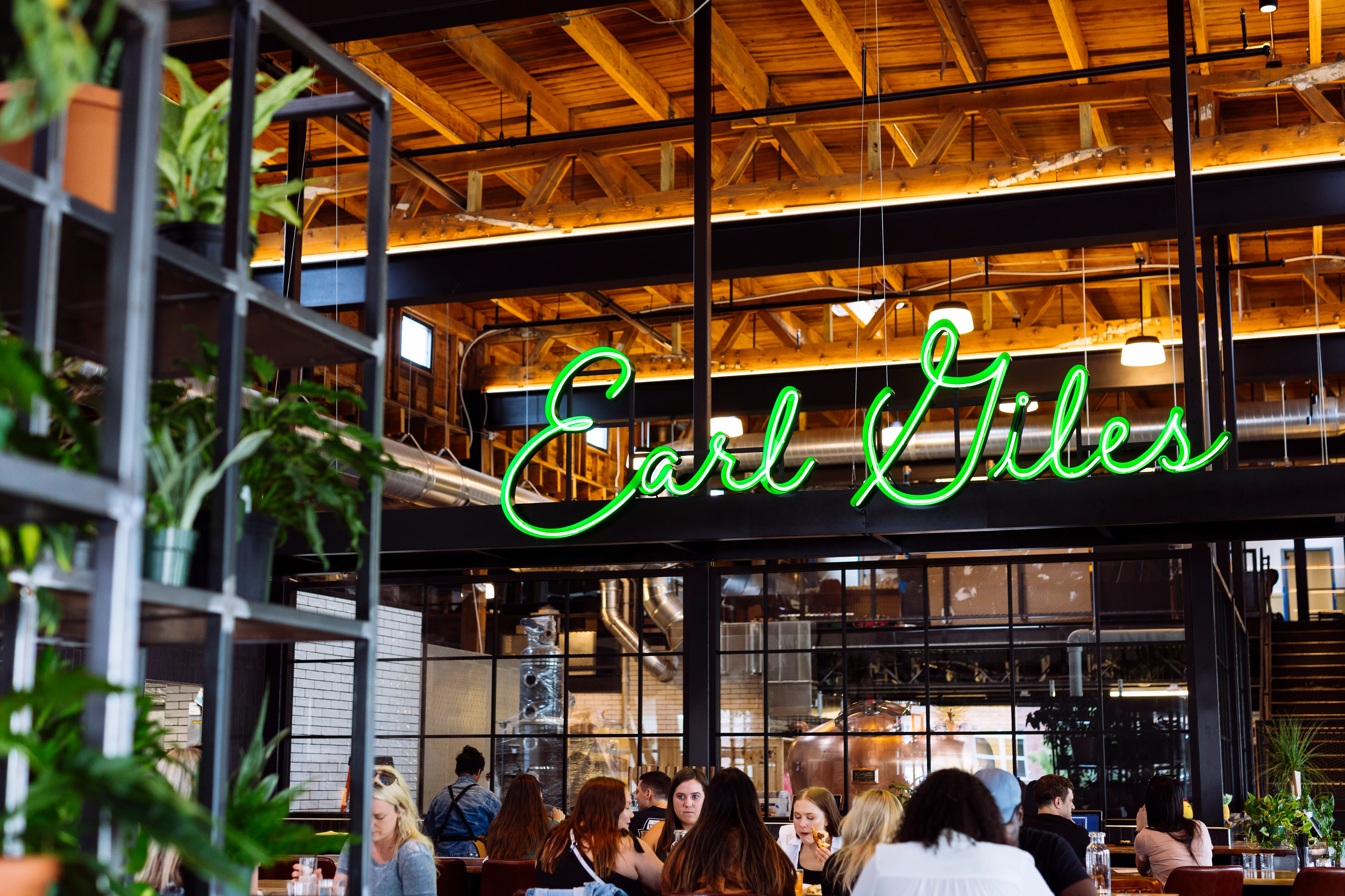 Modern restaurant interior with neon sign and greenery