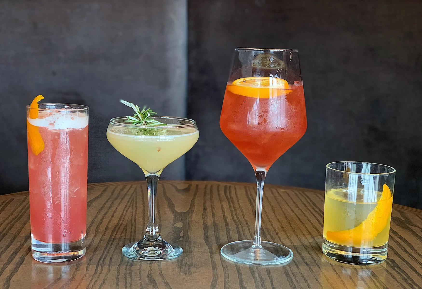 Colorful cocktails on a wooden table at a modern bar