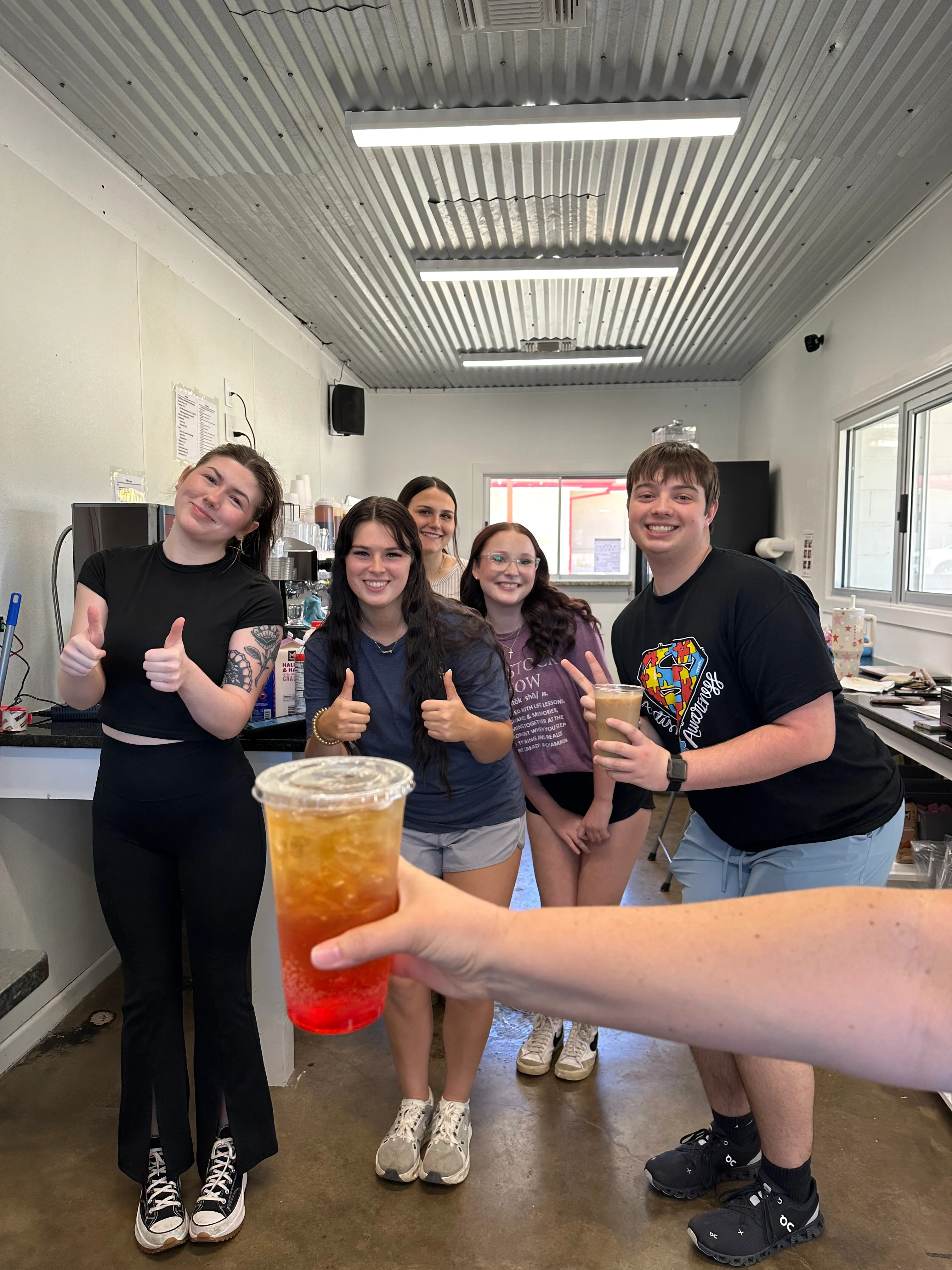 Friendly staff posing with drinks in a vibrant café setting