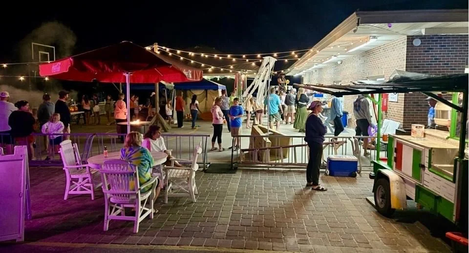 Outdoor night market with food stalls and festive lights