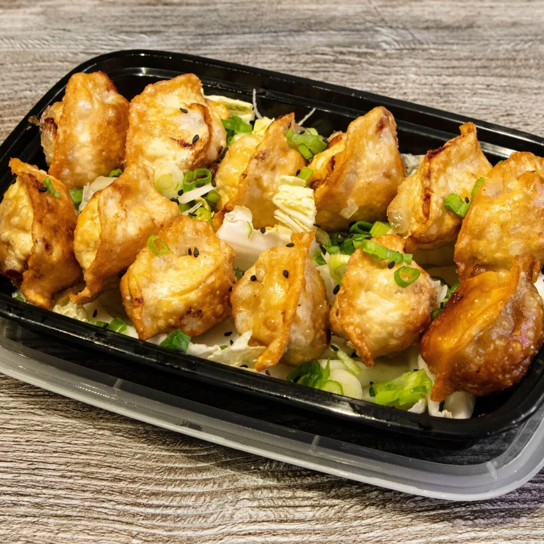 Fried dumplings served on a bed of cabbage with green onions.