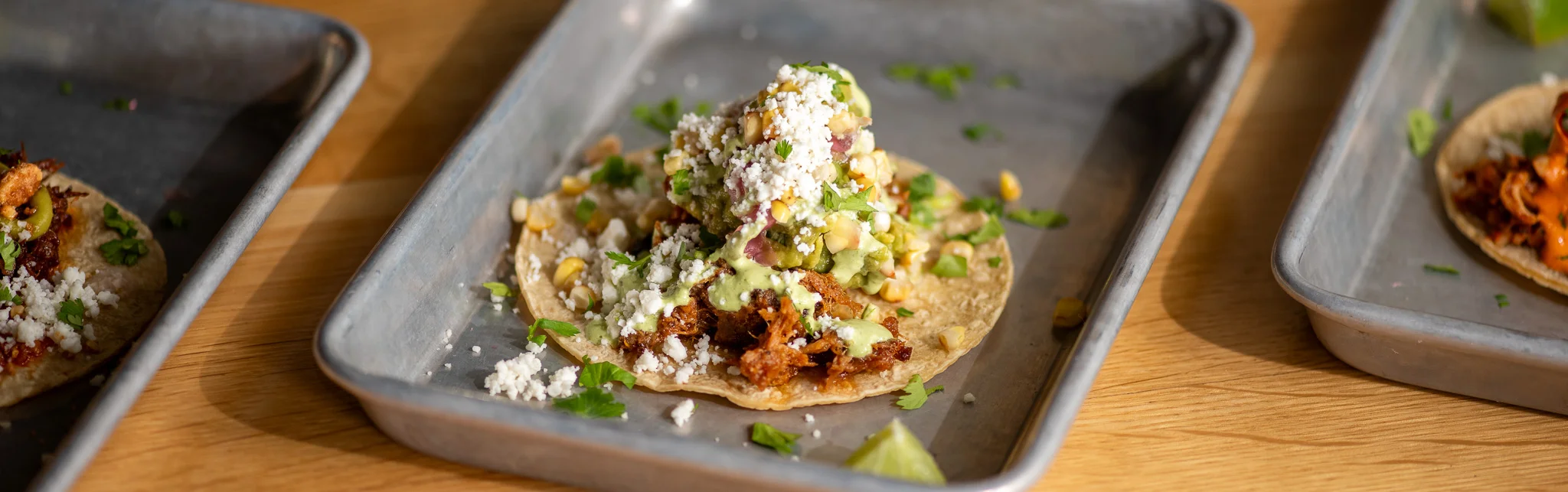 Delicious Mexican street tacos topped with guacamole and cheese