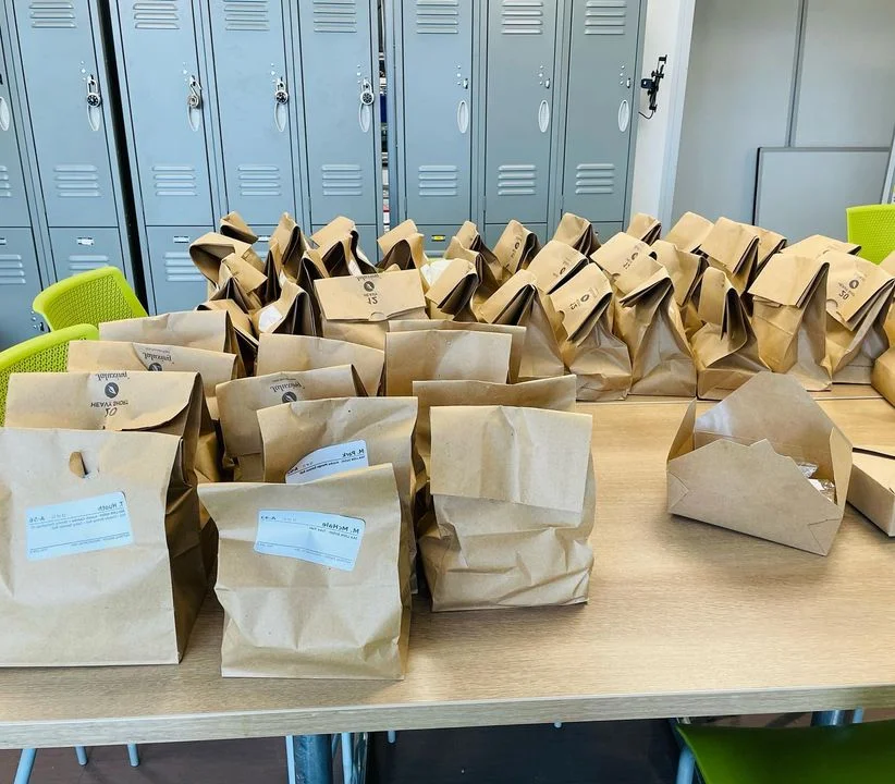 Packed takeout bags ready for delivery in a dining area