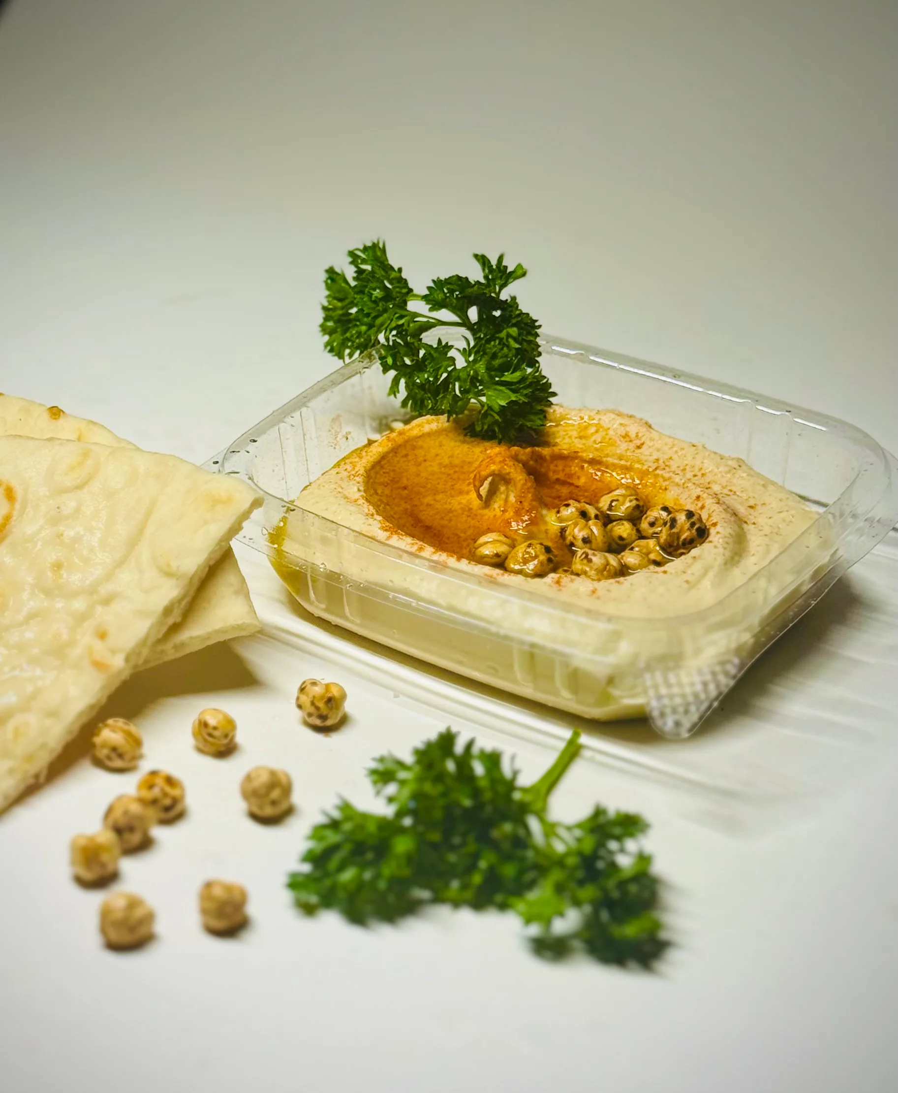Creamy hummus served with pita and garnished with parsley