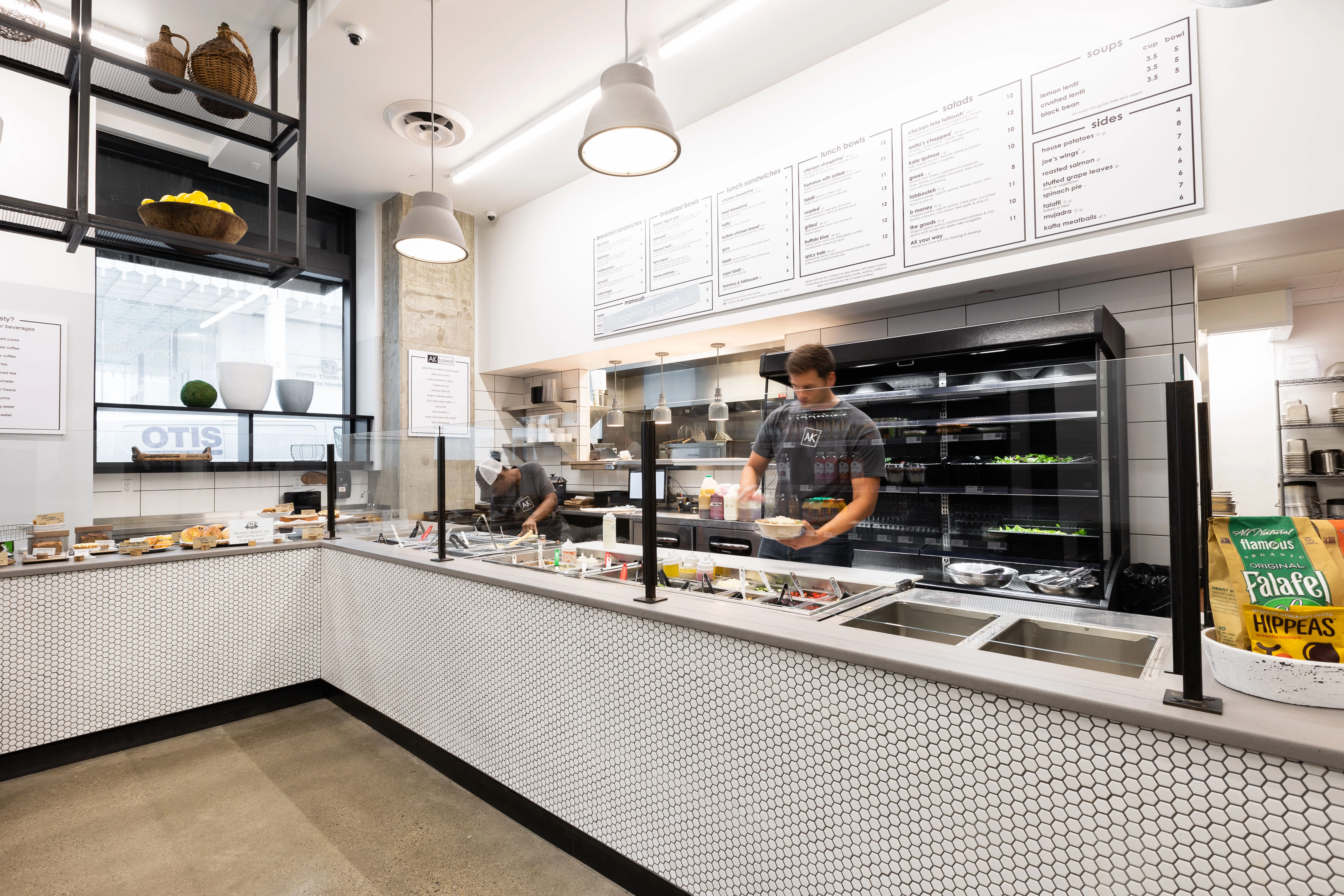 Modern restaurant interior with open kitchen and menu board