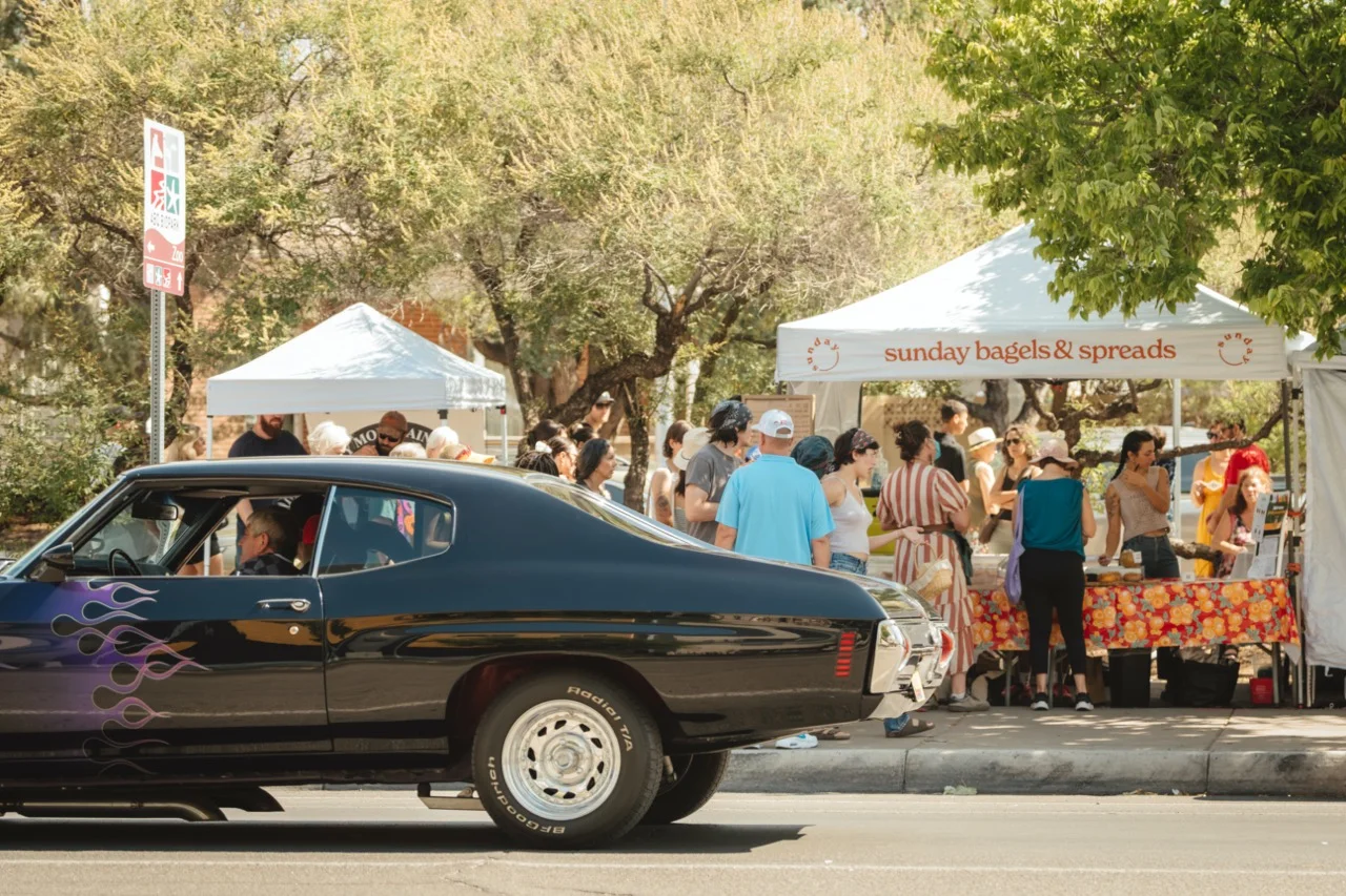 Crowd enjoying bagels at a vibrant outdoor market