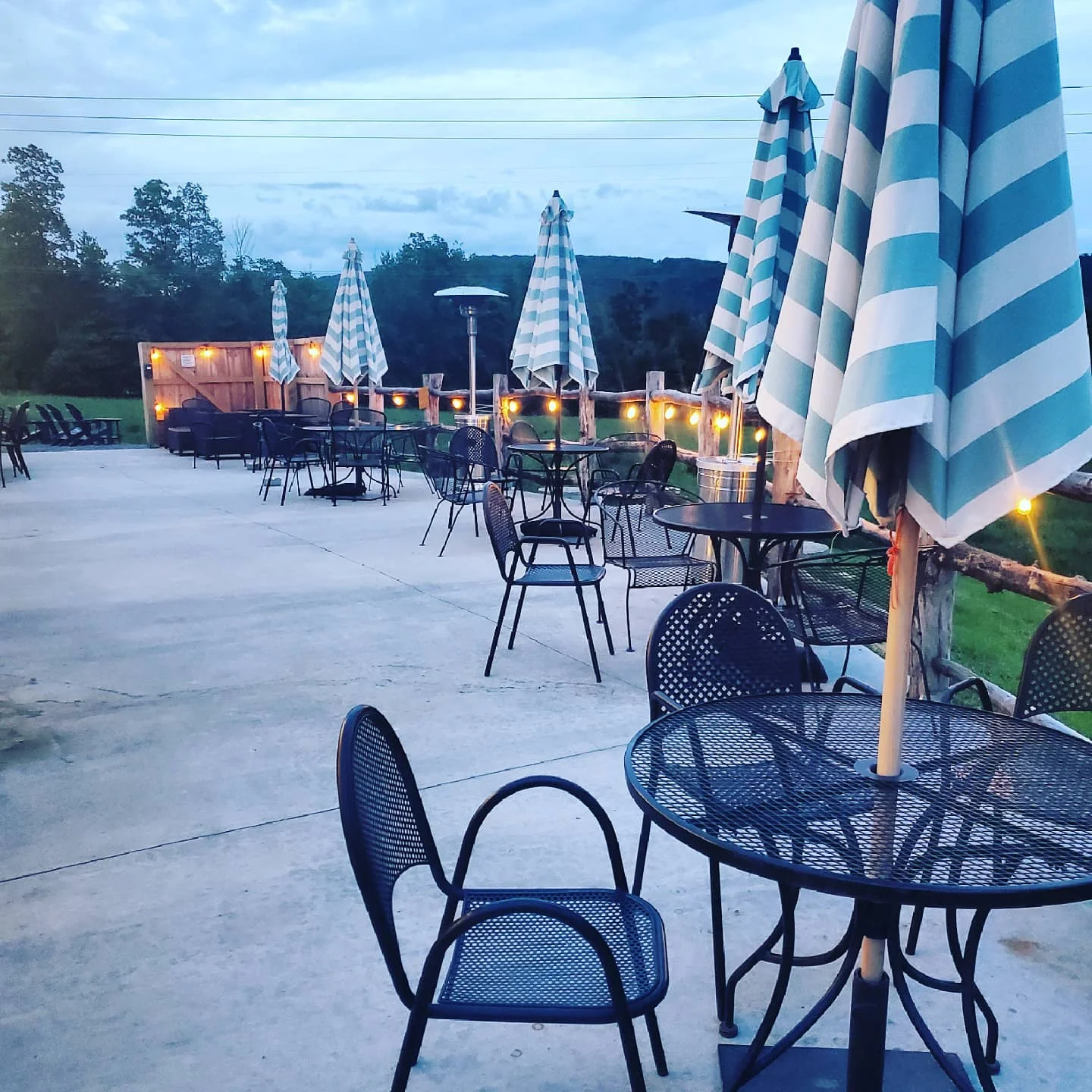 Outdoor dining area with striped umbrellas and cozy lighting