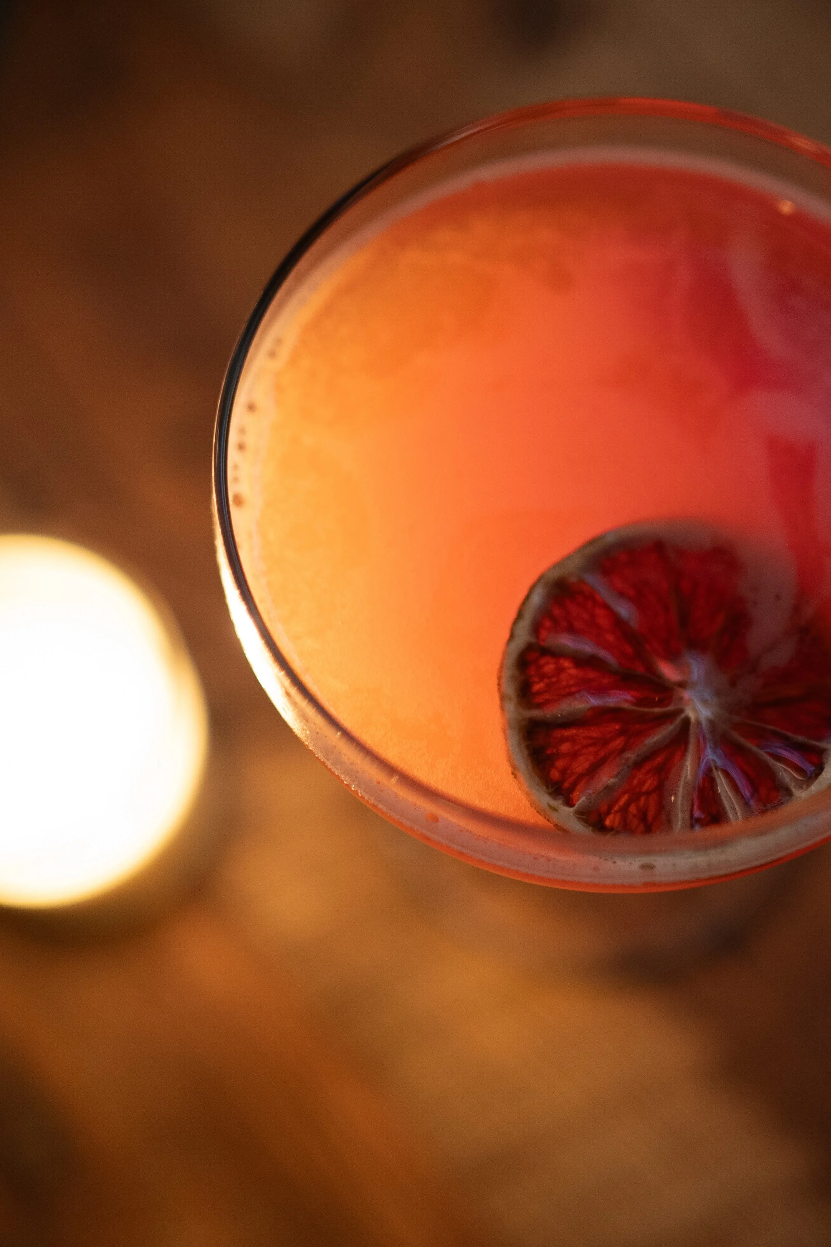 Vibrant cocktail with dried citrus garnish in a cozy setting