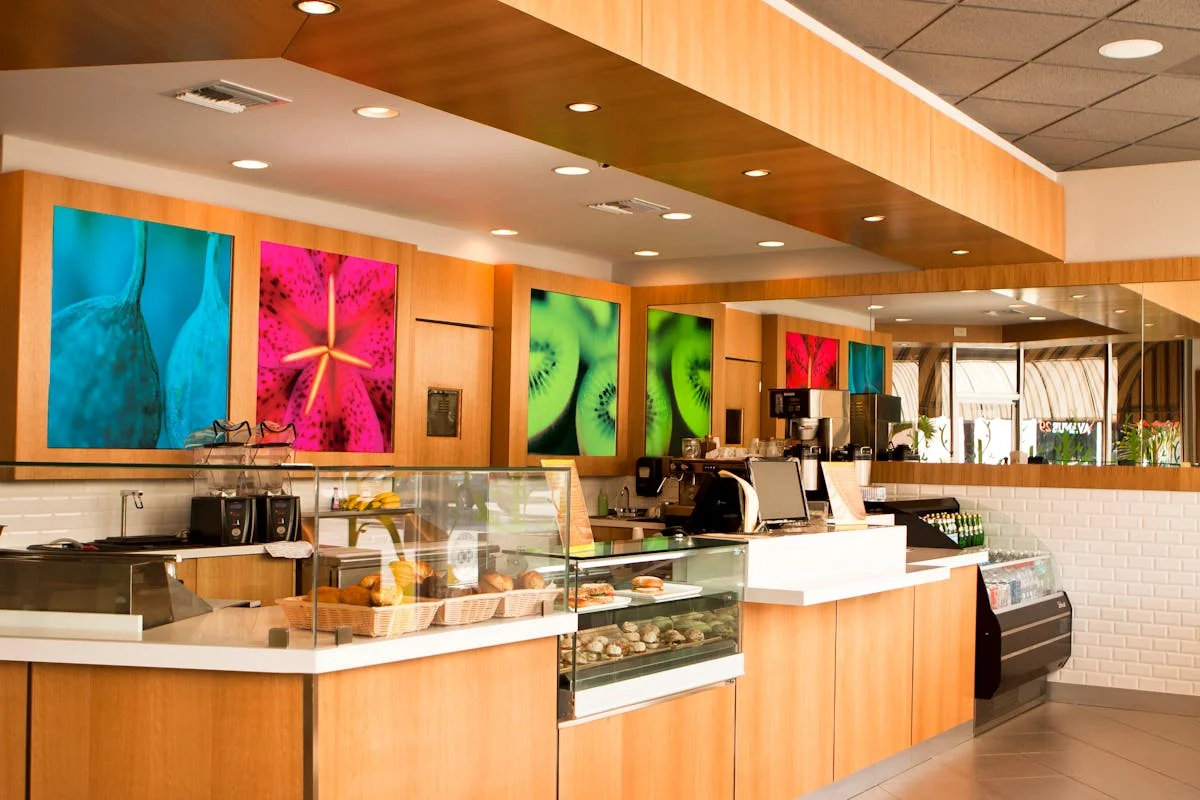 Interior of a modern café with colorful fruit-themed artwork.