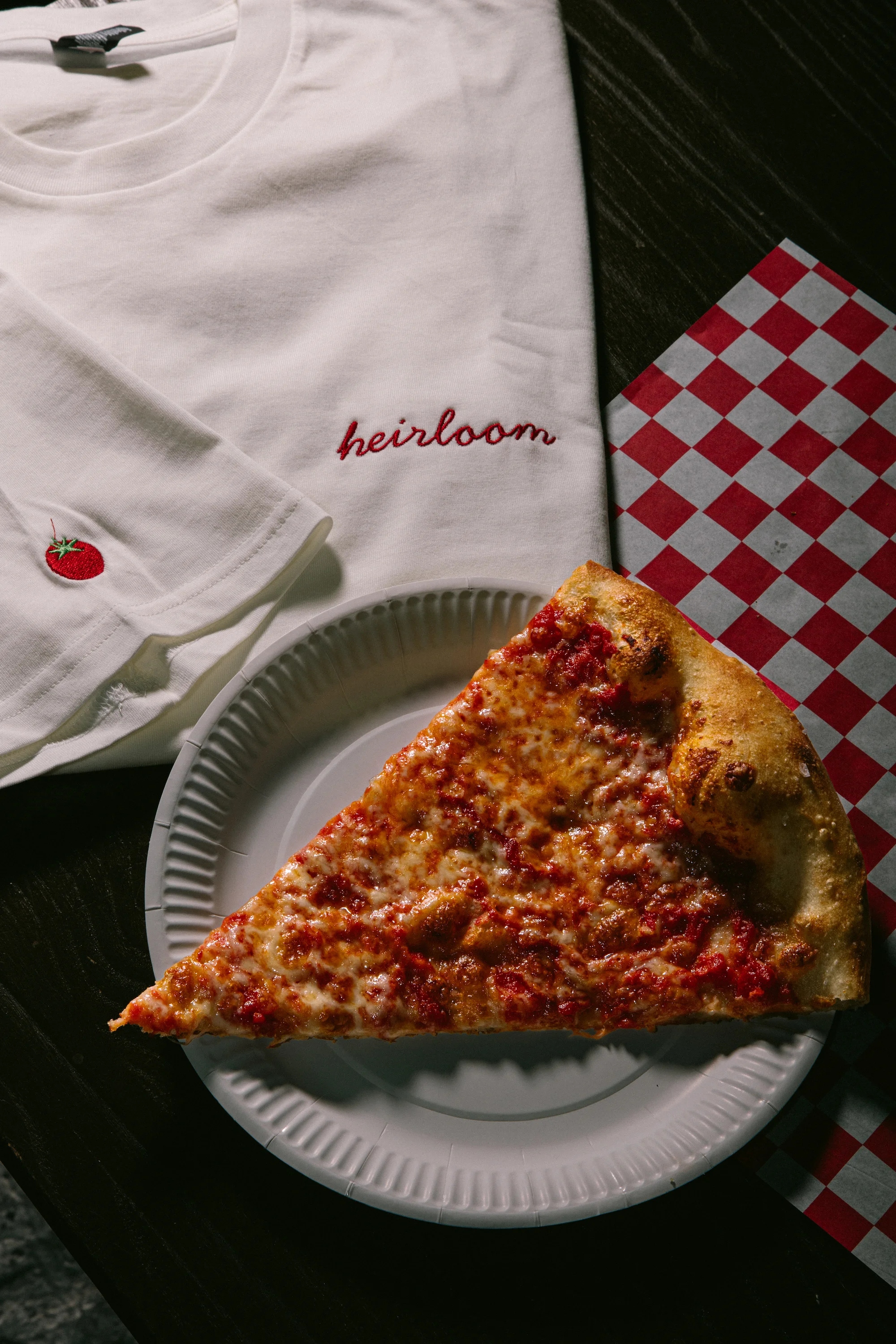 Slice of classic New York-style pizza on a paper plate