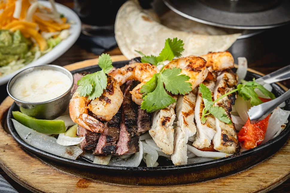 Sizzling fajitas with shrimp, chicken, and steak
