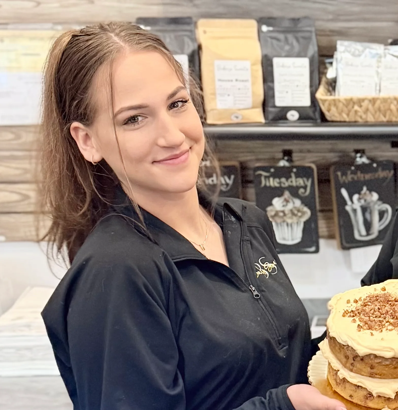 Bakery staff presenting a layered cake inside a café