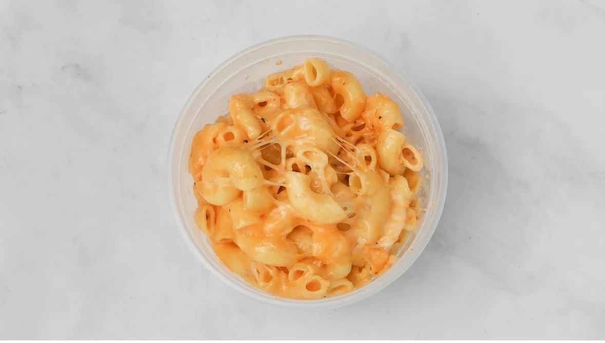 Creamy macaroni and cheese in a clear container.