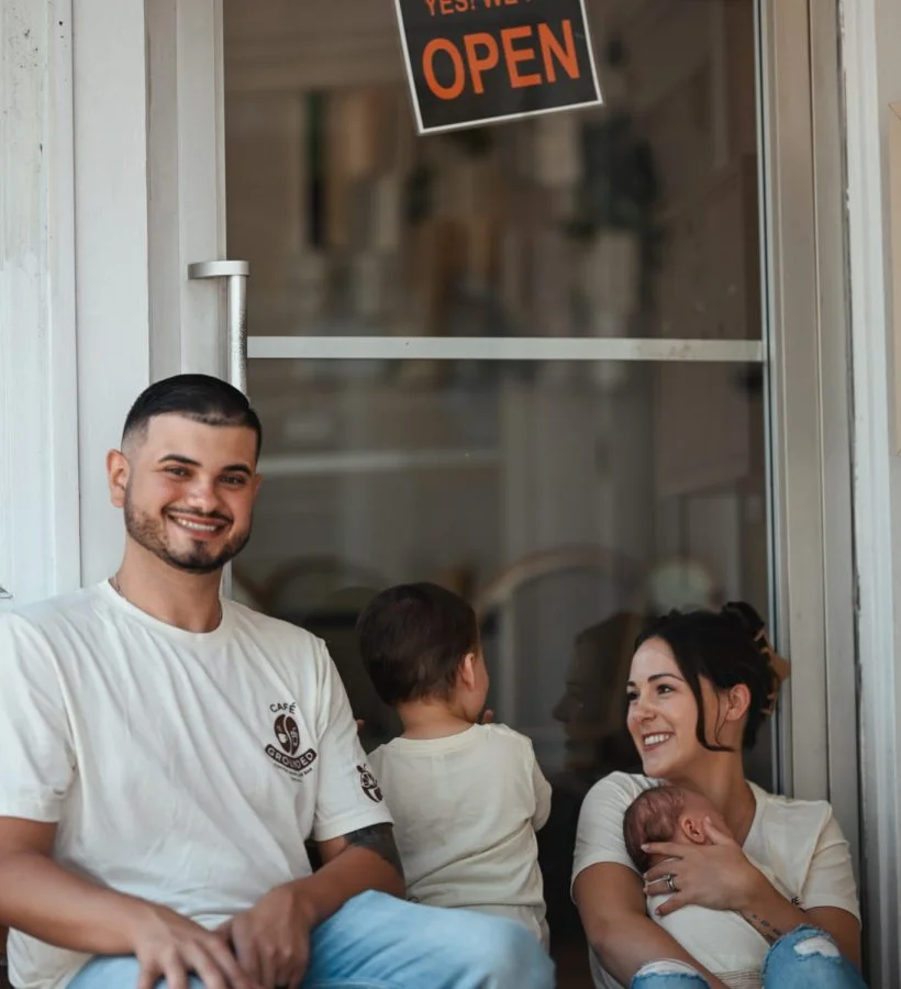 Family enjoying time outside a cafe with an open sign