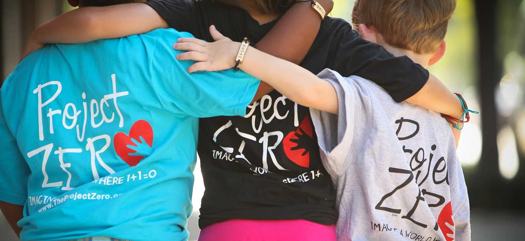 Children wearing Project Zero t-shirts embracing each other