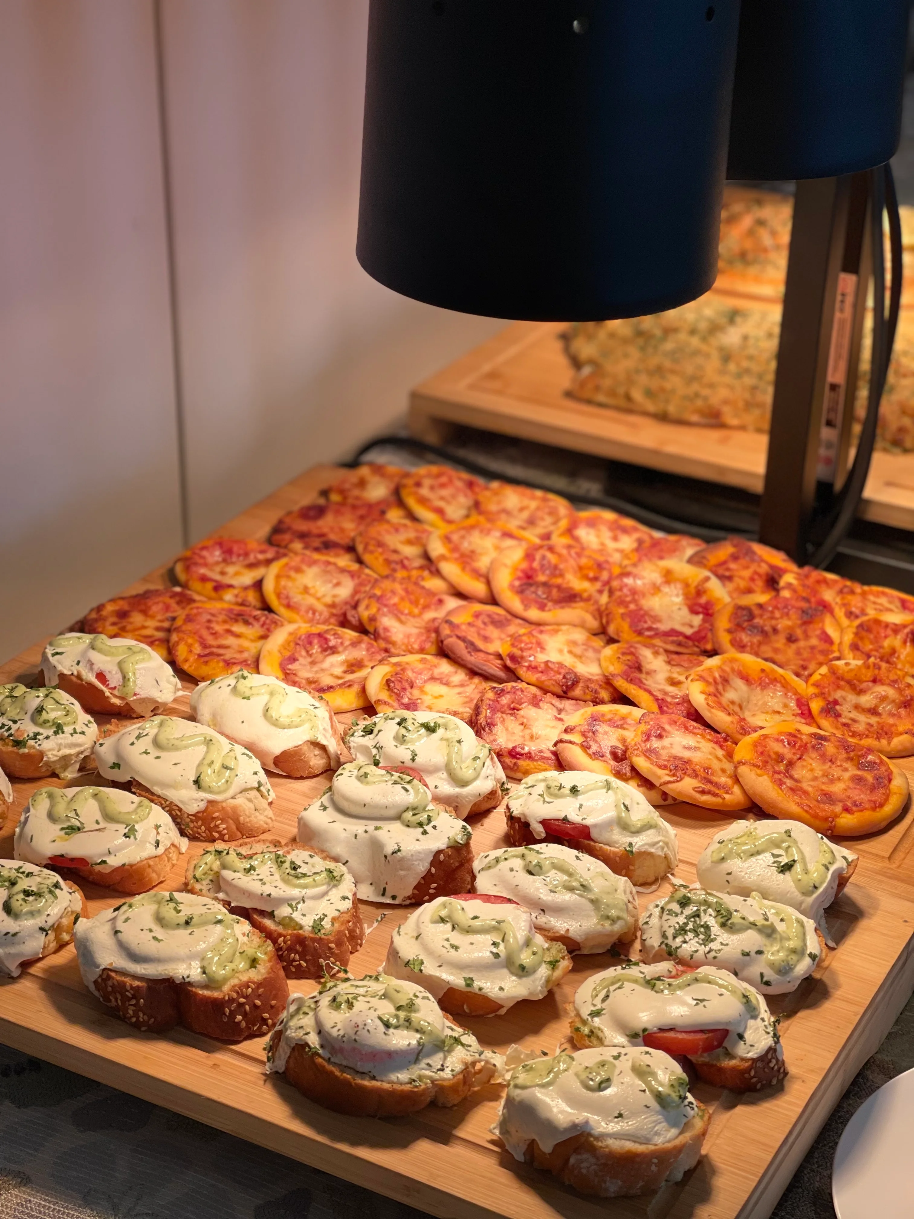 Assorted Italian bruschetta and mini pizzas on a wooden platter