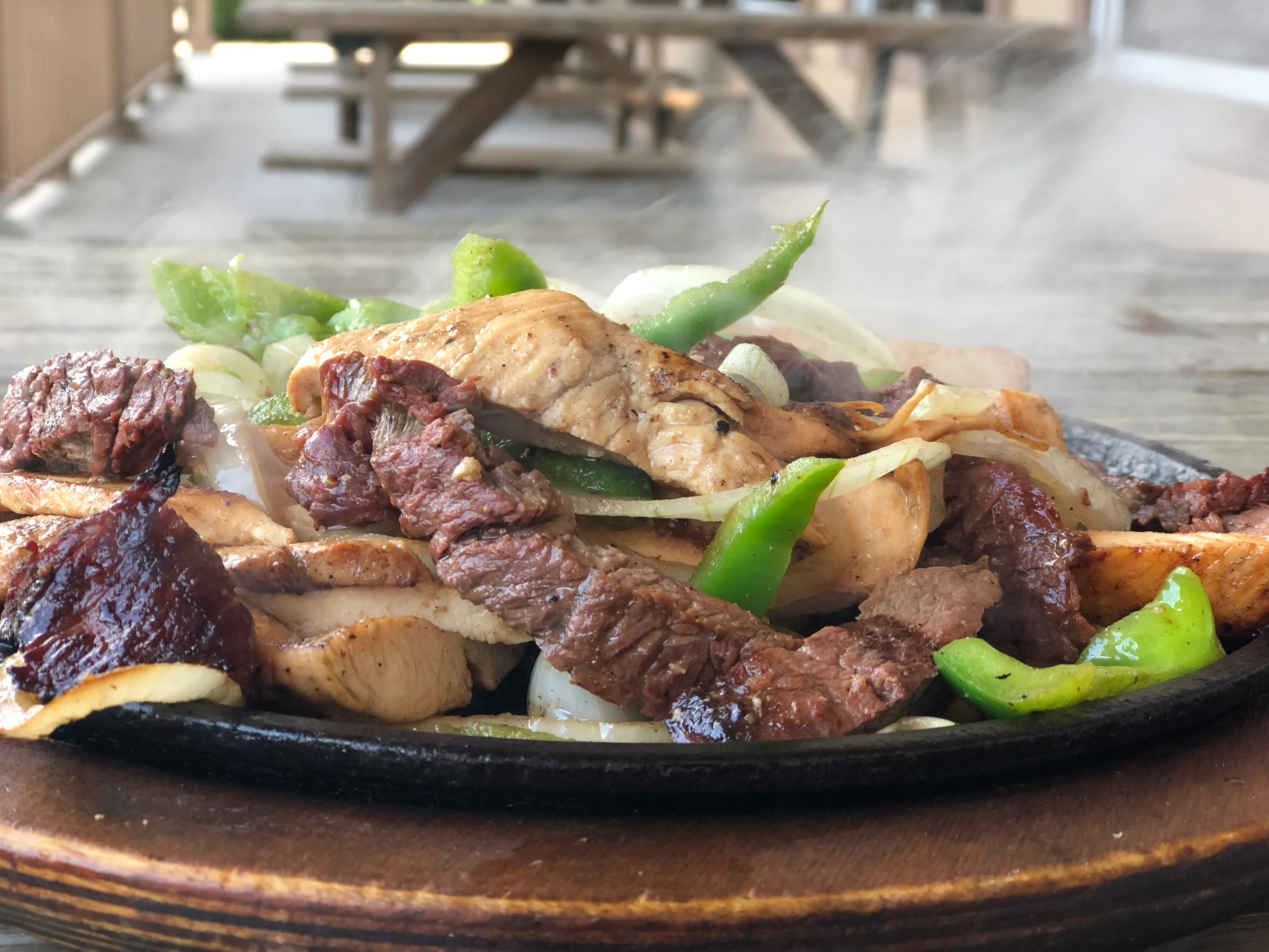 Sizzling fajitas with chicken and beef on a hot plate