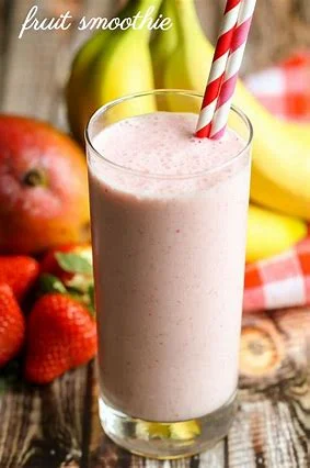 Refreshing fruit smoothie in a tall glass with a striped straw