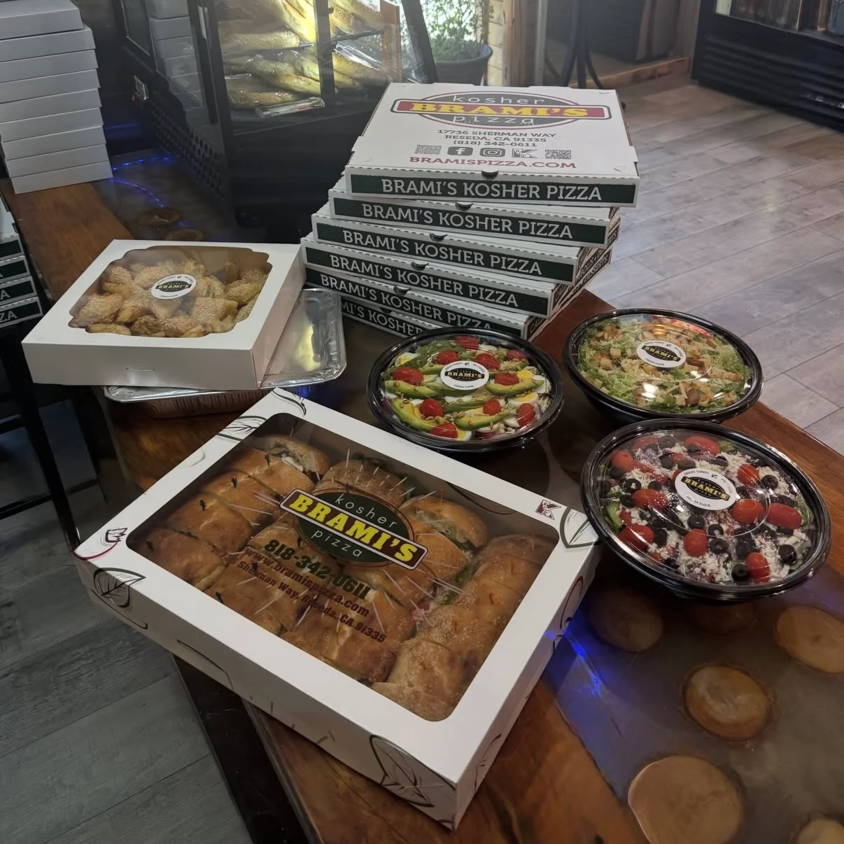 Assorted kosher pizza and salads from a restaurant display