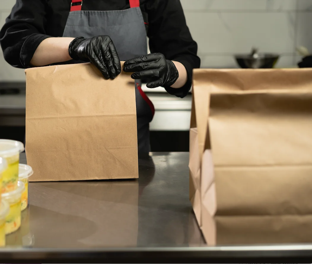 Chef preparing takeout bags in a modern kitchen