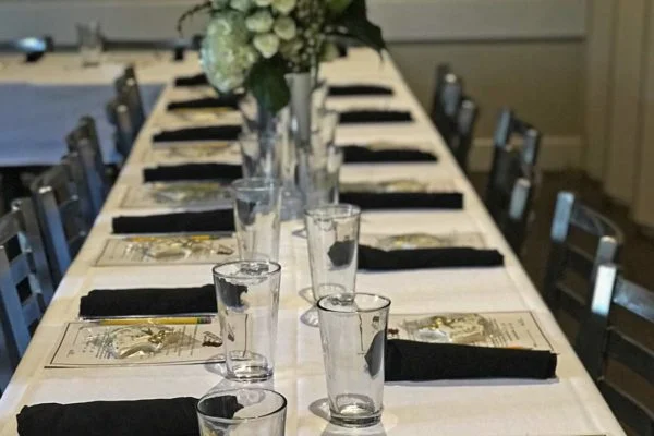 Elegant dining setup with black napkins and floral centerpiece