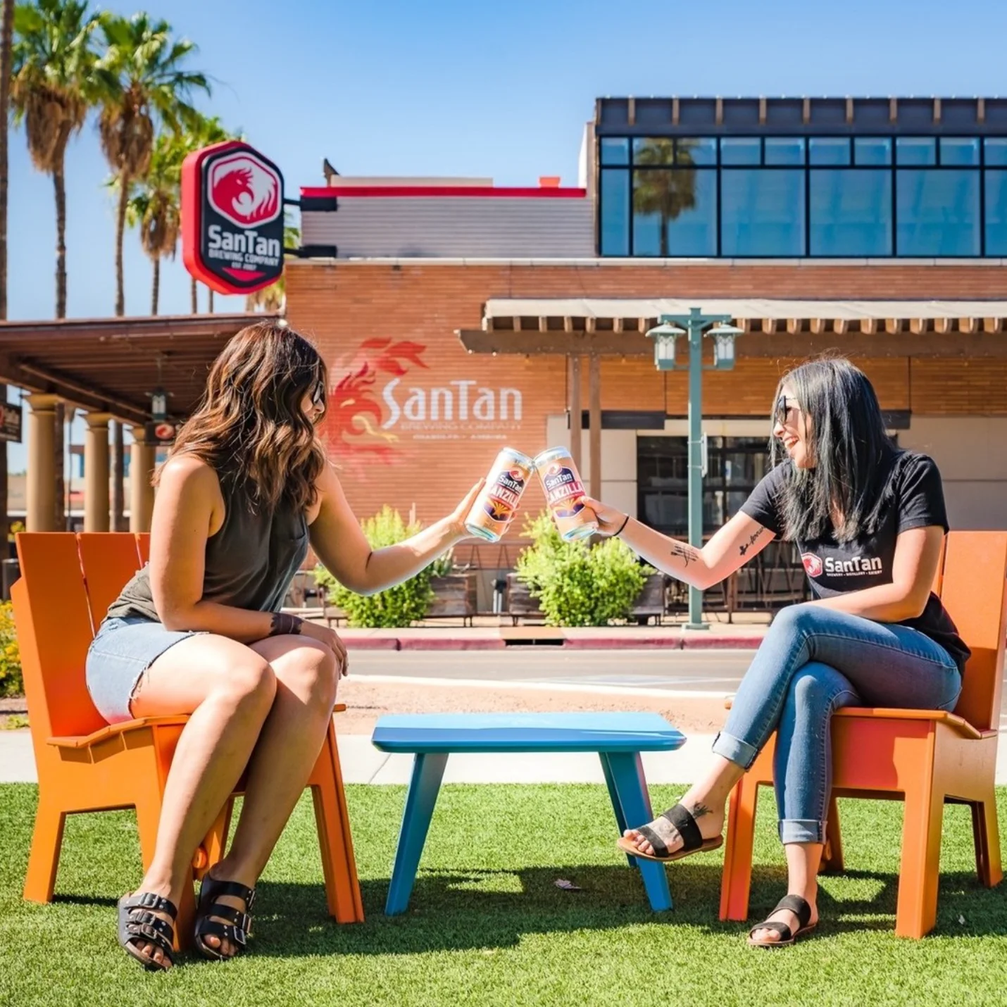 Two friends toasting drinks outside SanTan Brewery