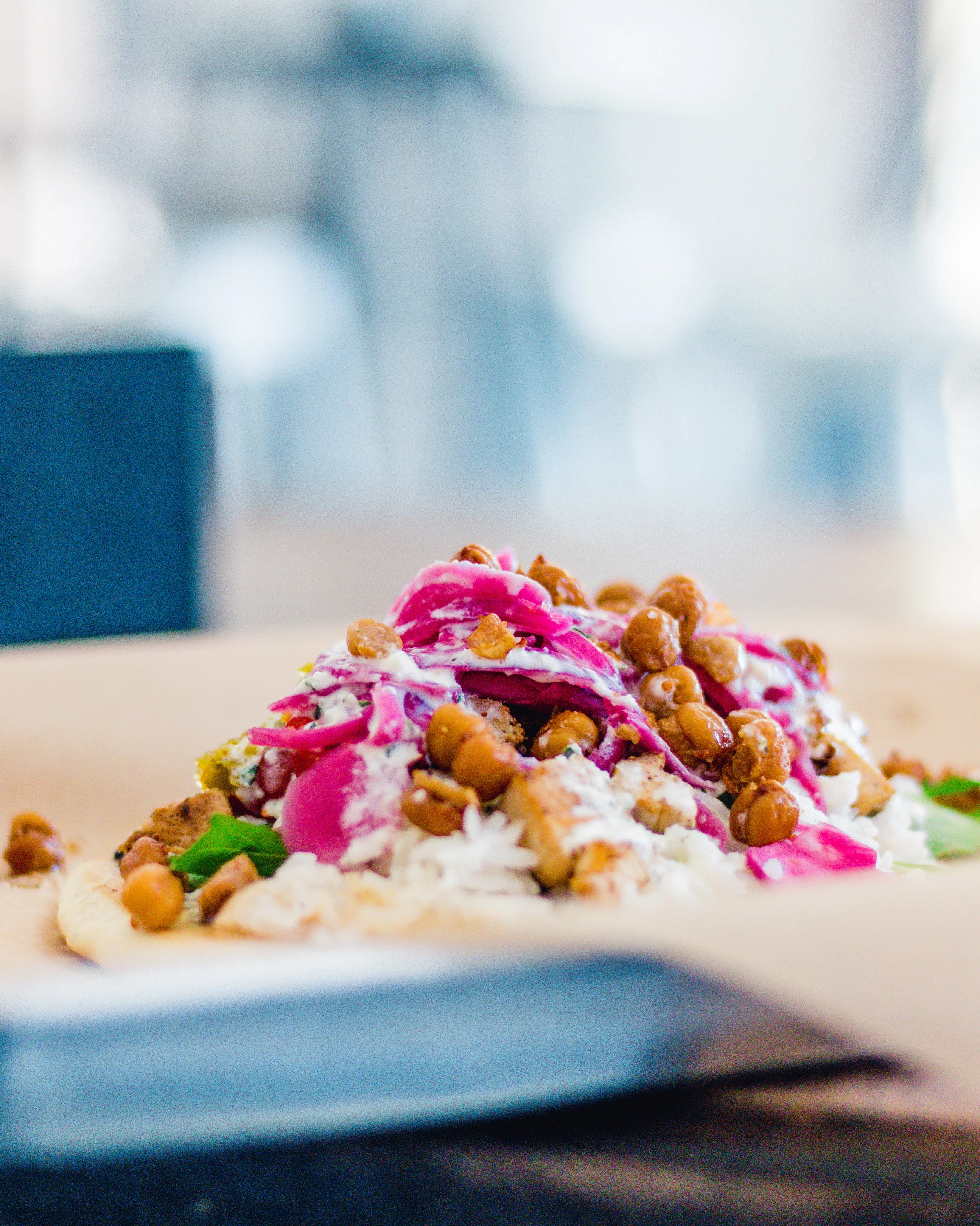 Colorful Mexican tostada topped with beans and creamy sauce