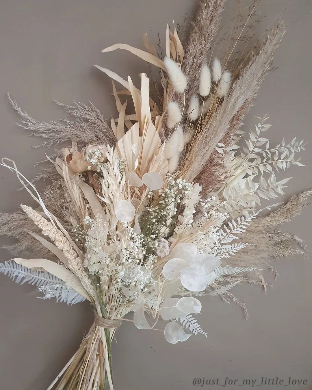 Dried floral bouquet in neutral tones on a textured background