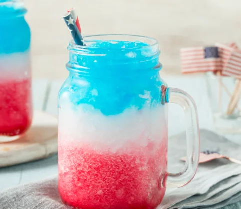 Colorful layered slush drink in a mason jar