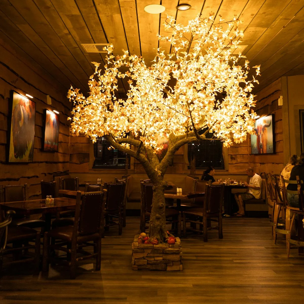 Cozy restaurant interior with illuminated tree centerpiece