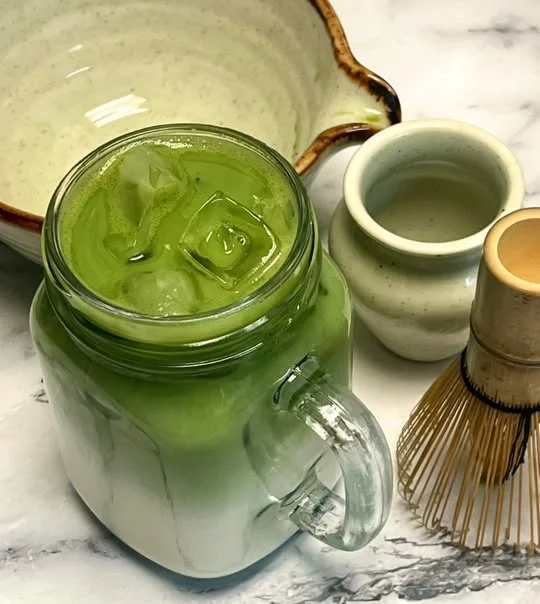 Iced matcha latte in a glass jar with milk